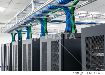 Organized server racks with neatly managed blue and green cables in a data center Organized server racks with neatly managed blue and green cables in a data center 142341375