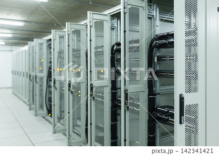 Modern server room with rows of network racks and blinking lights 142341421