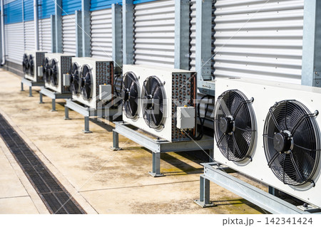 Outdoor air conditioning units lined up on a rooftop with corrugated metal wall Outdoor air conditioning units lined up on a rooftop with corrugated metal wall 142341424