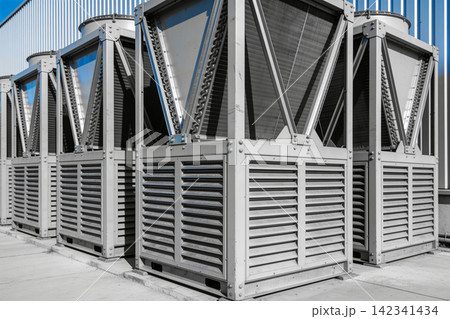 Industrial HVAC units lined up outside a building, showcasing modern climate control systems Industrial HVAC units lined up outside a building, showcasing modern climate control systems 142341434