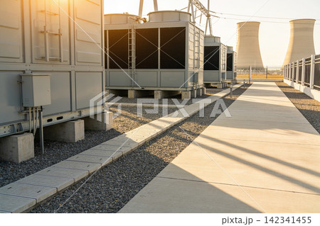 Industrial cooling towers and HVAC units under warm sunlight on a clear day 142341455
