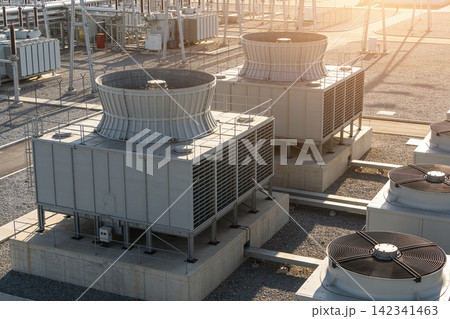 Industrial cooling towers and HVAC units on a rooftop with electrical transformers Industrial cooling towers and HVAC units on a rooftop with electrical transformers 142341463