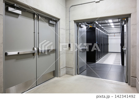 Modern server room entrance with double emergency exit doors and rows of data cabinets Modern server room entrance with double emergency exit doors and rows of data cabinets 142341492