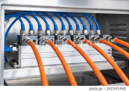 Industrial pneumatic manifold with blue and orange tubes connected Industrial pneumatic manifold with blue and orange tubes connected 142341498