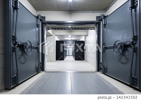 Massive vault doors open to reveal a modern server room with rows of black cabinets Massive vault doors open to reveal a modern server room with rows of black cabinets 142341502