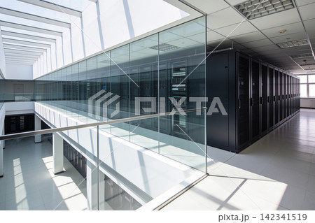 Modern data center with rows of server racks behind glass walls Modern data center with rows of server racks behind glass walls 142341519