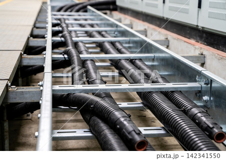 Industrial electrical conduits organized neatly in a metal cable tray system Industrial electrical conduits organized neatly in a metal cable tray system 142341550