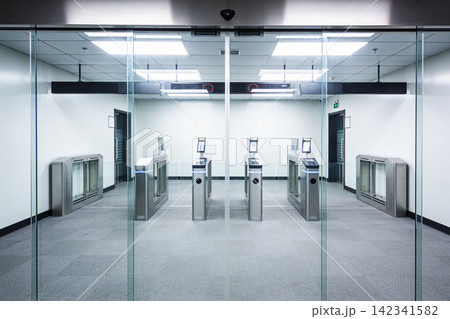 Modern office building entrance with automated security turnstiles and glass doors Modern office building entrance with automated security turnstiles and glass doors 142341582