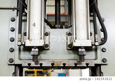 Close-up of industrial hydraulic cylinders and mechanical components in a factory Close-up of industrial hydraulic cylinders and mechanical components in a factory 142341612