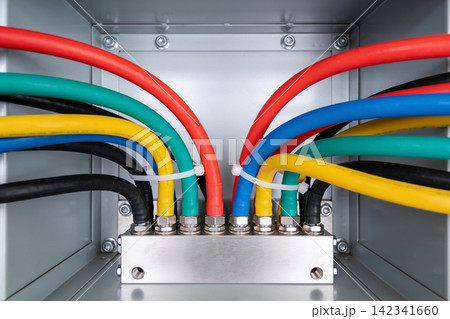 Organized electrical wiring with colorful cables neatly secured inside a metal enclosure Organized electrical wiring with colorful cables neatly secured inside a metal enclosure 142341660