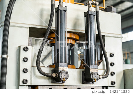 Heavy duty industrial hydraulic cylinders and machinery components in a factory setting Heavy duty industrial hydraulic cylinders and machinery components in a factory setting 142341826
