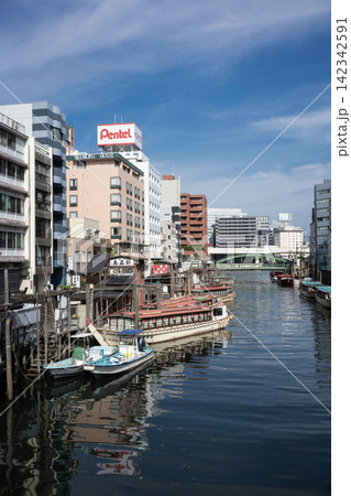 神田川の係留所に並ぶ伝統的な屋形船と、下町のビル群が織りなす浅草橋の風景 神田川の係留所に並ぶ伝統的な屋形船と、下町のビル群が織りなす浅草橋の風景 142342591