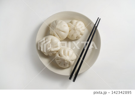 Steamed bao buns served on a white ceramic plate 142342895
