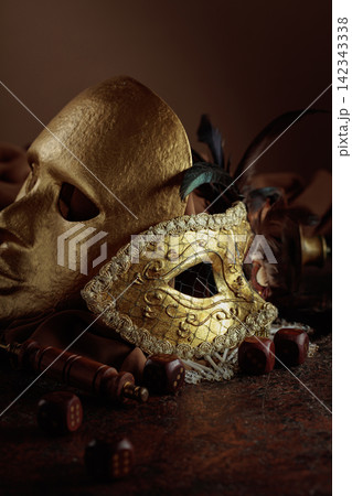 Golden vintage carnival masks with old wooden dices. Golden vintage carnival masks with old wooden dices. 142343338