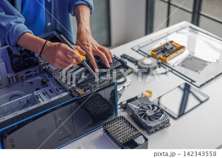 Computer engineer repairing computer motherboard and hardware components. 142343558