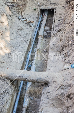 Excavated water pipes after replacement near the old house. Pipe Excavated water pipes after replacement near the old house. Pipe 142343809