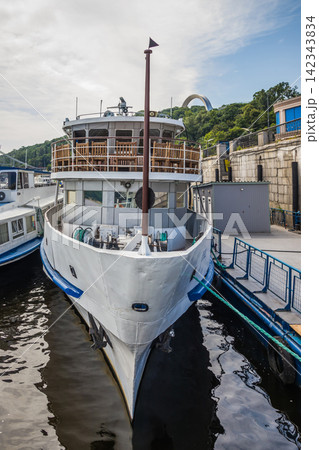 River ship at the pier. River pleasure boat moored in the port awaiting boarding of passengers. Walks on holidays and weekends. River ship at the pier. River pleasure boat moored in the port awaiting boarding of passengers. Walks on holidays and weekends. 142343834