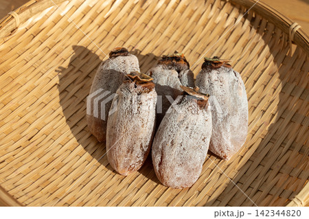 ザルにのせた白い粉付きの枯露柿(干し柿) 柿霜 12月 ザルにのせた白い粉付きの枯露柿(干し柿) 柿霜 12月 142344820