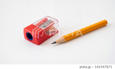 Yellow wooden pencil beside a red plastic manual pencil sharpener with sharpener transparent stationery supplies education learning graphite sharpened equipment composition background 142347671