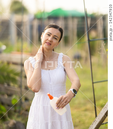 Using mosquito repellent - woman applying mosquito repellent to skin Using mosquito repellent - woman applying mosquito repellent to skin 142347910