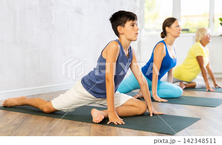 Group of people perform pigeon asana Group of people perform pigeon asana 142348511
