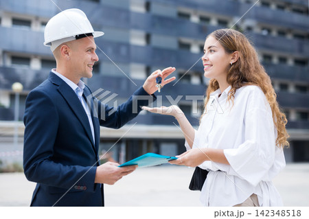 Builder giving keys to client after finishing signing contract 142348518