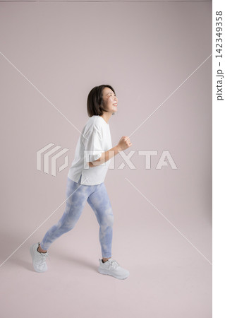 笑顔でランニングやウォーキングを楽しむ女性、健康維持のために運動するアクティブな40代 142349358