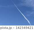 青空を斜めに伸びる白い飛行機雲 142349421