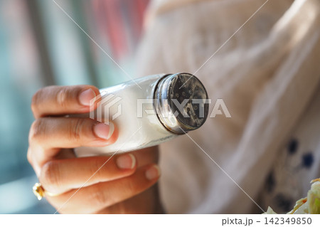 Person with salt shaker at cafe lunch 142349850