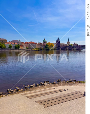 View of Charles Bridge in Prague on a clear day with reflections in the river View of Charles Bridge in Prague on a clear day with reflections in the river 142350005