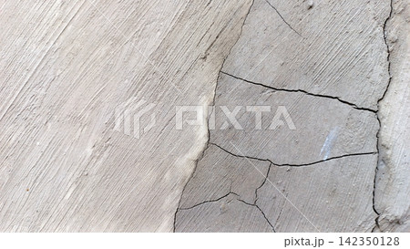 Branching cracks on the surface of a diagonal textured concrete wall. 142350128