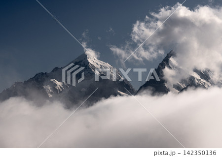 Snow Covered Mountain Peaks Rising Above Thick White Clouds Snow Covered Mountain Peaks Rising Above Thick White Clouds 142350136