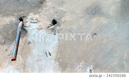 Weathered concrete wall with metal rods, cavities, and a brushed texture. Weathered concrete wall with metal rods, cavities, and a brushed texture. 142350280