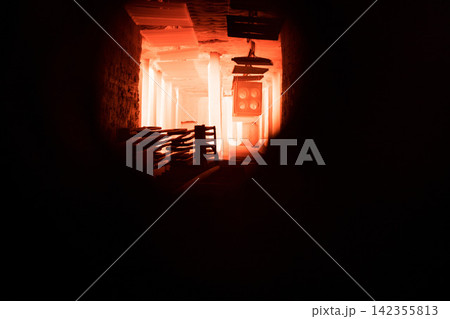 Industrial furnace interior glowing with intense orange light through dark tunnel view Industrial furnace interior glowing with intense orange light through dark tunnel view 142355813