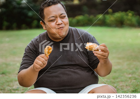 portrait of a happy fat man eating lots of fried chicken portrait of a happy fat man eating lots of fried chicken 142356236