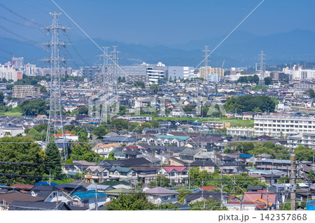 東京都日野市の高台から見下ろす広大な住宅街と送電鉄塔 142357868