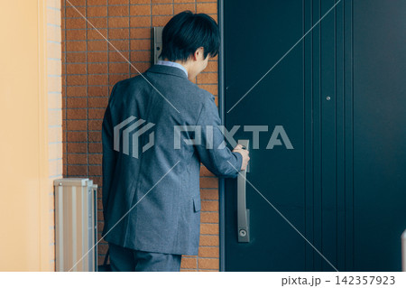 玄関で鍵を開ける男性 玄関で鍵を開ける男性 142357923