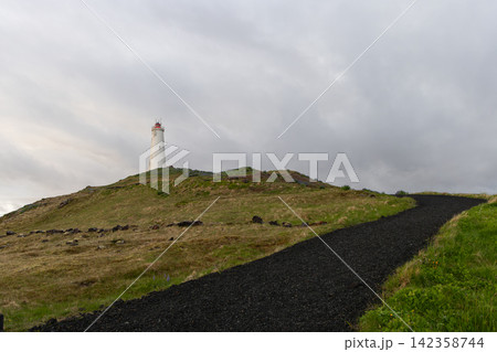 Reykjanes Lighthouse standing among rough grass beside a sloping footpath, Iceland Reykjanes Lighthouse standing among rough grass beside a sloping footpath, Iceland 142358744