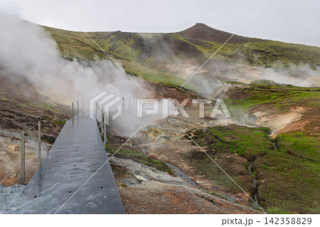 Hveradalir with a wet boardwalk leading through a steaming valley, Hengill, Iceland Hveradalir with a wet boardwalk leading through a steaming valley, Hengill, Iceland 142358829