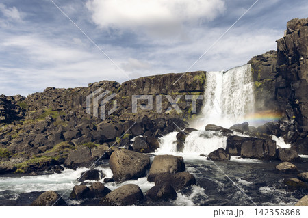 Oxararfoss waterfall with a diagonal cliff edge meeting the falling water, Thingvellir, Iceland 142358868