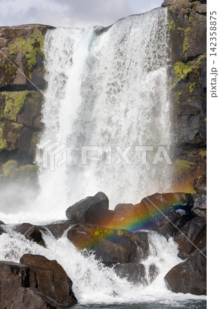 Oxararfoss with a narrow cascade framed high between black cliffs, Thingvellir, Iceland Oxararfoss with a narrow cascade framed high between black cliffs, Thingvellir, Iceland 142358875