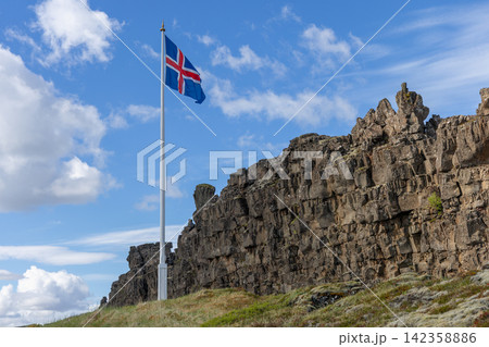Icelandic flag standing over the rift valley and distant ridges, Thingvellir, Iceland 142358886