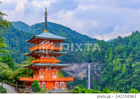 晩夏の午後の曇り空 熊野那智大社側から美しく望む朱色の三重塔と遠方の那智の滝 142358961