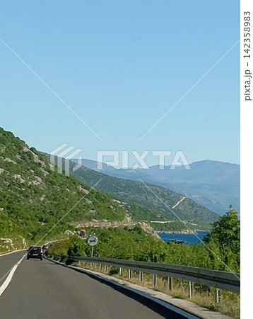 Mountain Road Along a Turquoise Lake Mountain Road Along a Turquoise Lake 142358983