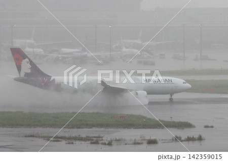雨の滑走路に着陸する旅客機 エンジンの逆噴射の水煙 雨の滑走路に着陸する旅客機 エンジンの逆噴射の水煙 142359015
