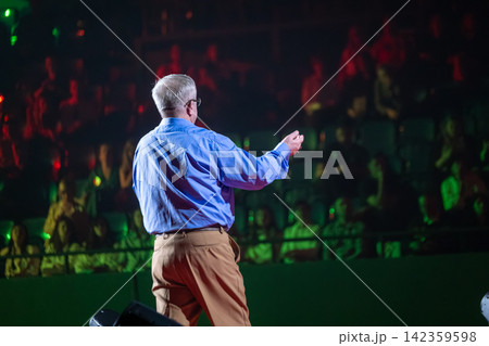 Presenter using an open gesture before conference audience 142359598