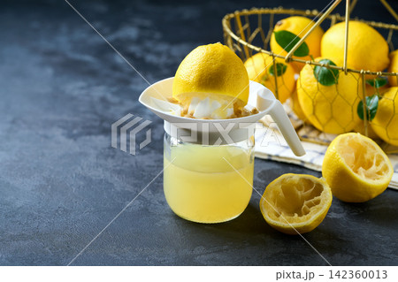 homemade lemon juice in small bowl on dark table with copy space for text. freshly squeezed lemon juice . 142360013