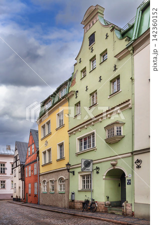Historic street with colorful houses in Old Town of Riga, Latvia. Beautiful green facade and traditional medieval architecture Historic street with colorful houses in Old Town of Riga, Latvia. Beautiful green facade and traditional medieval architecture 142360152