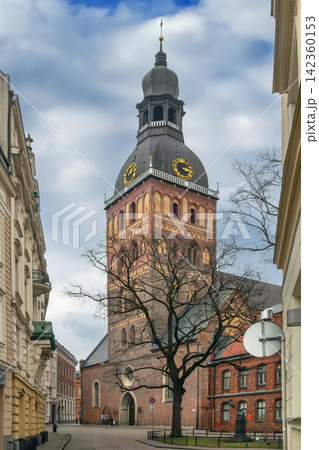 View of Riga Cathedral tower and small square on a cloudy February day, Latvia. Historic Lutheran cathedral and city street View of Riga Cathedral tower and small square on a cloudy February day, Latvia. Historic Lutheran cathedral and city street 142360153