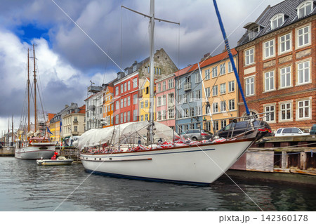 Nyhavn Canal with luxury yacht and colorful houses in Copenhagen, Denmark. View from the water with no people, scenic travel Nyhavn Canal with luxury yacht and colorful houses in Copenhagen, Denmark. View from the water with no people, scenic travel 142360178